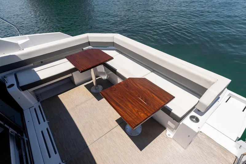Slide: The Image of Luxurious seating area on 2022 Cruisers Yachts 42 Cantius, featuring elegant wooden tables. - 30