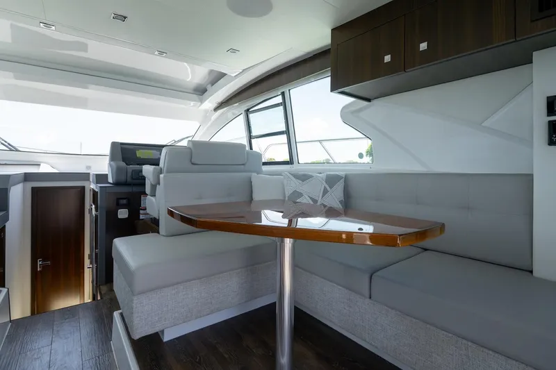 Slide: The Image of Luxurious interior of 2022 Cruisers Yachts 42 Cantius with elegant seating and wooden table. - 37