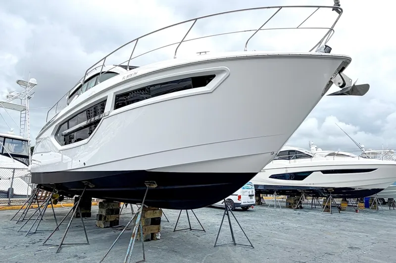 Slide: The Image of 2022 Cruisers Yachts 42 Cantius on stands, sleek design, cloudy sky background. - 60