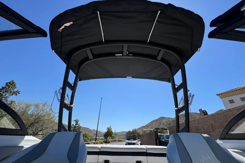 Slide: The Image of 2022 Tahoe 210 Si Limited boat interior with canopy, blue sky background. - 14