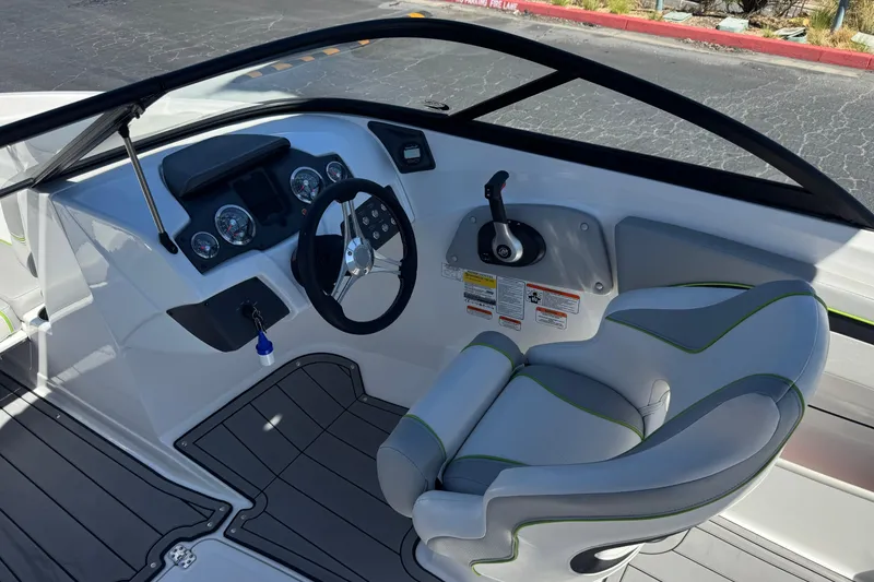 Slide: The Image of 2022 Tahoe 210 Si Limited boat interior with steering wheel and captain's seat. - 25