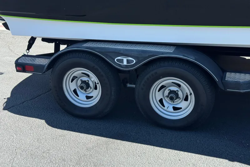Slide: The Image of Trailer wheels of a 2022 Tahoe 210 Si Limited boat on pavement. - 27