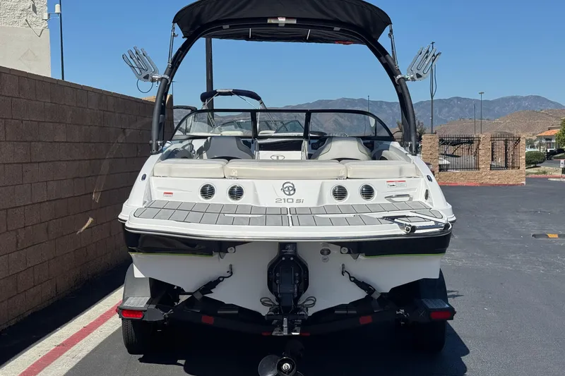 Slide: The Image of 2022 Tahoe 210 Si Limited boat, rear view, parked outdoors on a sunny day. - 4