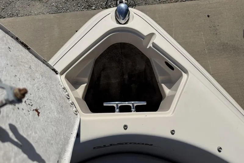 Slide: The Image of 1999 Glastron GT 225 boat bow with open storage compartment and cleat. - 11