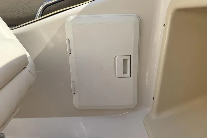 Slide: The Image of White storage compartment on a 1999 Glastron GT 225 boat interior. - 13