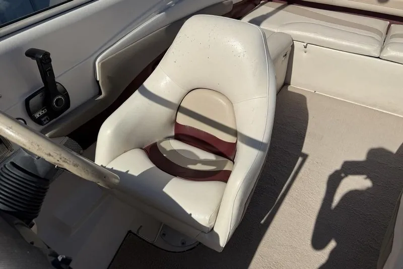 Slide: The Image of 1999 Glastron GT 225 boat interior with white captain's chair and control panel. - 15
