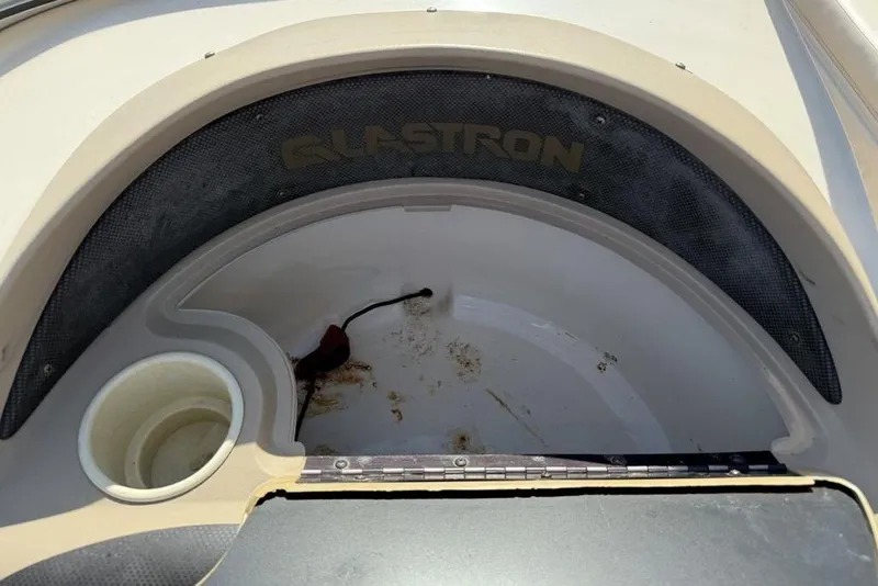 Slide: The Image of 1999 Glastron GT 225 boat interior with cup holder and storage compartment. - 17