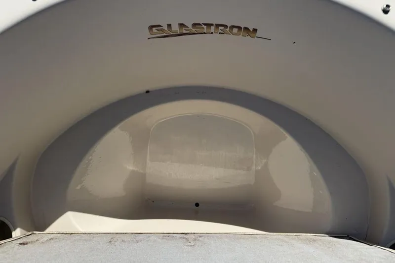 Slide: The Image of 1999 Glastron GT 225 boat interior with logo, showcasing sleek design. - 21