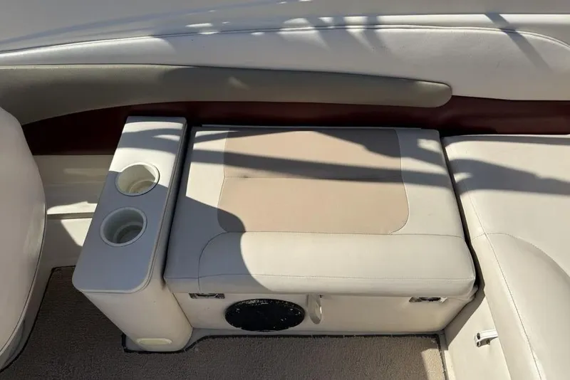 Slide: The Image of 1999 Glastron GT 225 boat interior with beige seating and cup holders. - 26