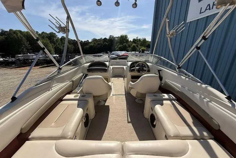 Slide: The Image of Interior view of a 1999 Glastron GT 225 boat with beige seating and steering wheel. - 35