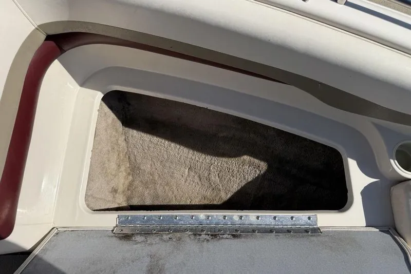 Slide: The Image of Storage compartment in a 1999 Glastron GT 225 boat, featuring carpeted interior and hinged lid. - 5
