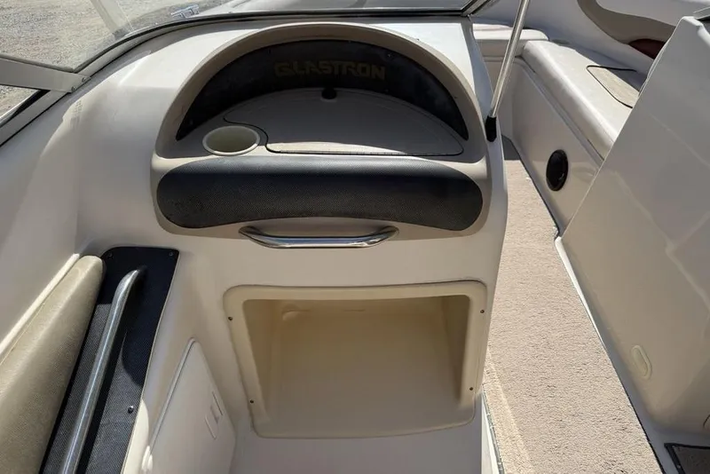 Slide: The Image of 1999 Glastron GT 225 boat interior with storage compartment and cup holder. - 9