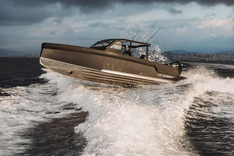 Slide: The Image of 2027 XO DFNDR 8 boat navigating rough waters with cityscape in the background. - 10