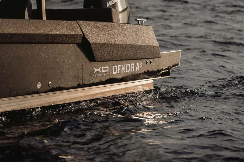 Slide: The Image of 2027 XO DFNDR 8 boat cruising on water, showcasing sleek design and modern features. - 12
