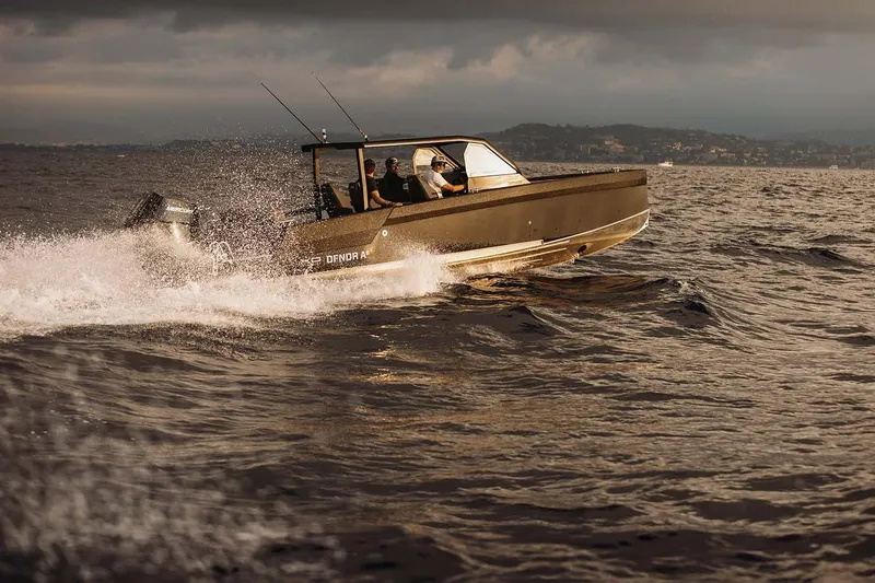 Slide: The Image of 2027 XO DFNDR 8 boat cruising on open water under cloudy skies. - 13