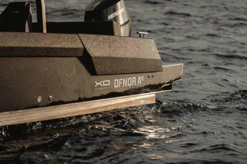 Slide: The Image of Sleek XO DFNDR 8 boat cruising on water, 2027 model. - 2