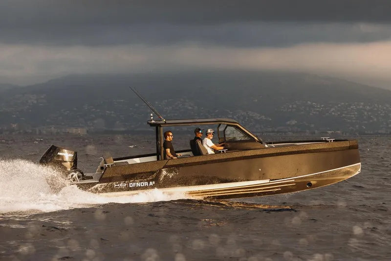 Slide: The Image of 2027 XO DFNDR 8 boat cruising on open water under cloudy skies. - 6