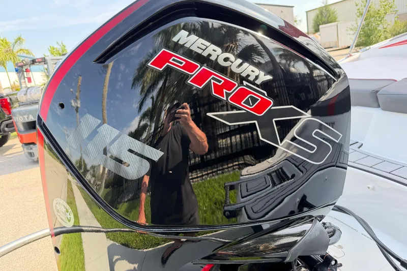 Slide: The Image of Mercury Pro XS 115 outboard motor on 2023 Tahoe T18 boat, reflecting palm trees. - 13