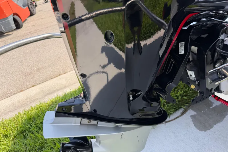 Slide: The Image of 2023 Tahoe T18 boat engine detail, shiny black finish, outdoor setting. - 14