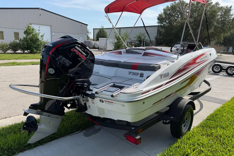 Slide: The Image of 2023 Tahoe T18 boat with Mercury engine, parked on a trailer, red canopy. - 18