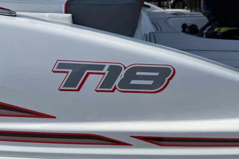 Slide: The Image of 2023 Tahoe T18 boat logo on sleek white surface with red accents. - 27