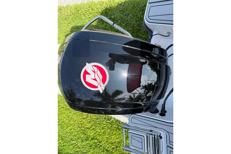 Slide: The Image of 2023 Tahoe T18 boat engine with logo, reflecting sky and trees. - 29