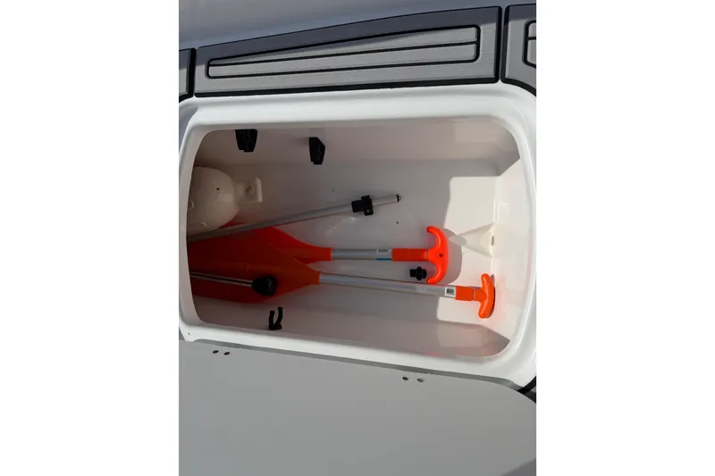 Slide: The Image of Storage compartment in 2023 Tahoe T18 boat with orange paddles and accessories. - 49