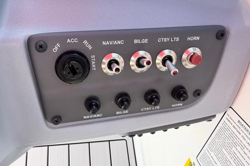 Slide: The Image of Control panel of a 2023 Tahoe T18 boat with switches and ignition. - 55