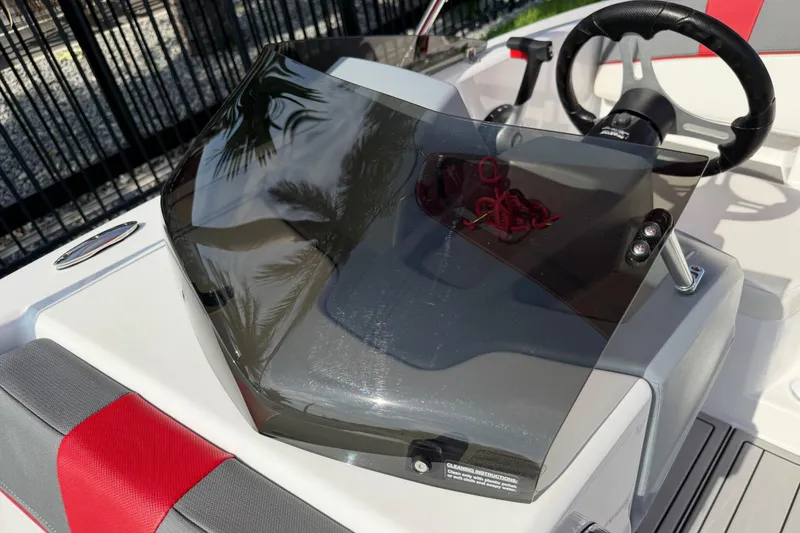 Slide: The Image of 2023 Tahoe T18 boat dashboard with steering wheel and tinted windshield. - 63