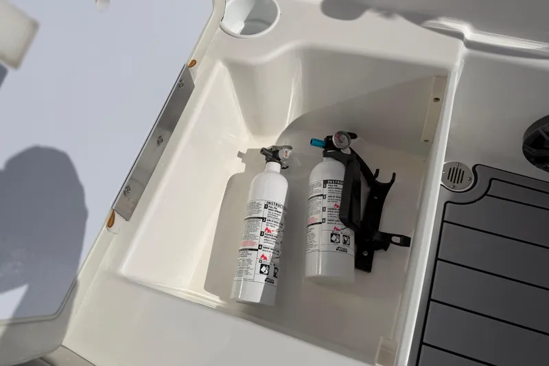 Slide: The Image of 2023 Tahoe T18 boat storage compartment with fire extinguishers and holder. - 70