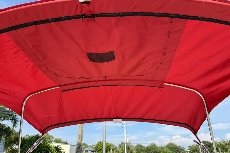 Slide: The Image of Red canopy of 2023 Tahoe T18 boat against blue sky background. - 77