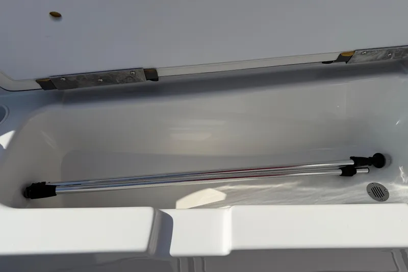 Slide: The Image of Open storage compartment in 2023 Tahoe T18 boat, featuring a telescopic pole. - 81