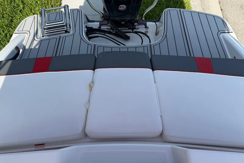Slide: The Image of 2023 Tahoe T18 boat deck with cushioned seating and motor, featuring sleek design elements. - 84