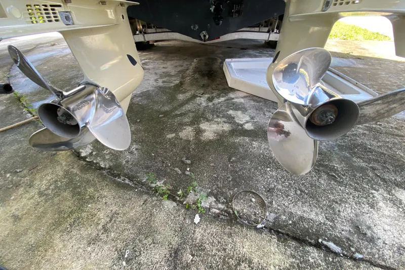Slide: The Image of 2002 Wellcraft 290 Coastal boat propellers on concrete surface, showcasing dual stainless steel blades. - 43