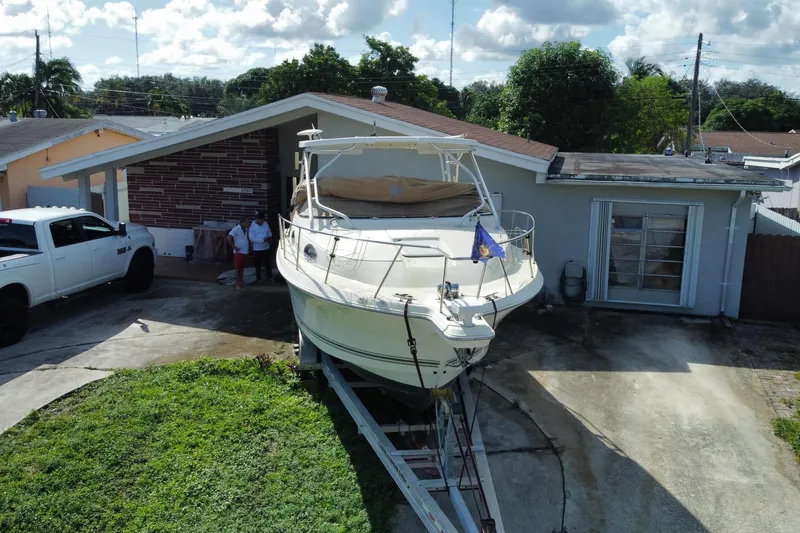 Slide: The Image of 2002 Wellcraft 290 Coastal boat on trailer in residential driveway, sunny day. - 6