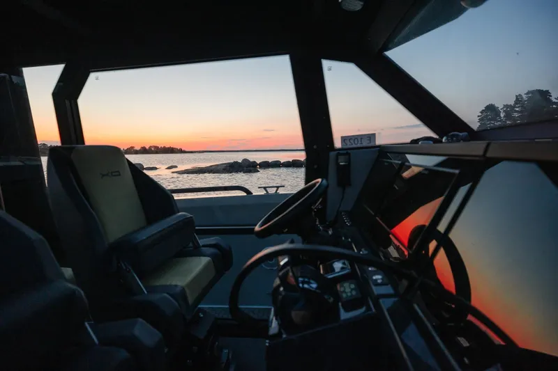 Slide: The Image of Interior view of 2027 XO DFNDR 9 boat at sunset, showcasing modern design and serene seascape. - 10