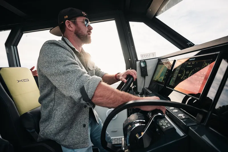 Slide: The Image of Man steering 2027 XO DFNDR 9 boat, focused on navigation screens. - 14