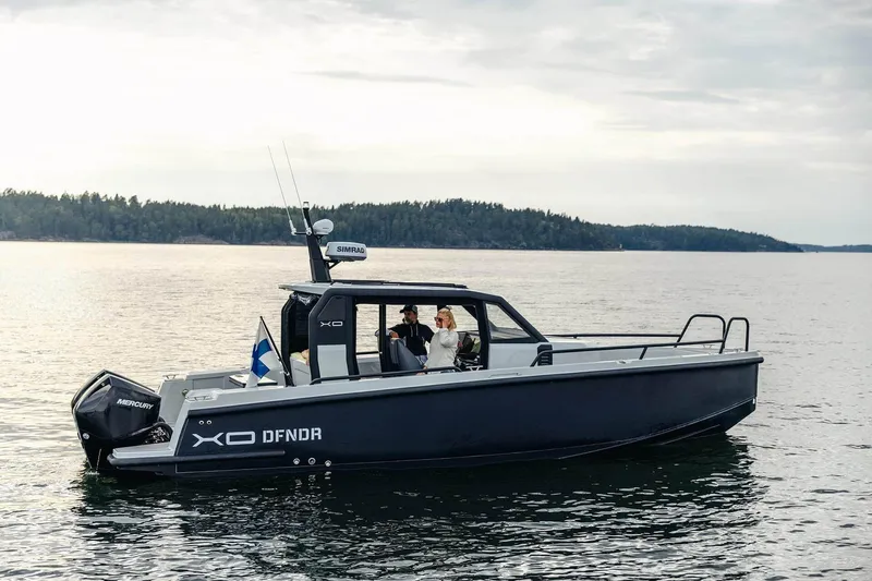 Slide: The Image of 2027 XO DFNDR 9 boat cruising on a serene lake with passengers onboard. - 16