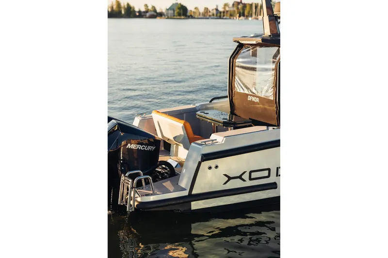 Slide: The Image of 2027 XO DFNDR 9 boat with Mercury engine, docked on calm water. - 21