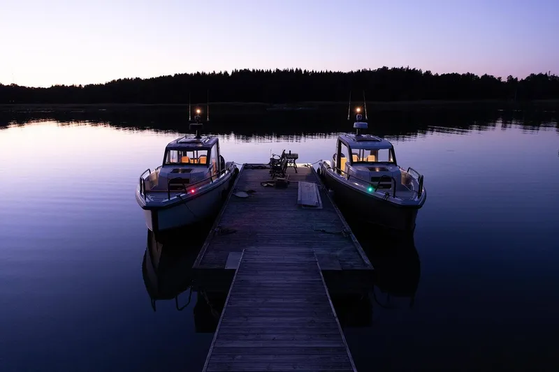 Slide: The Image of Two XO DFNDR 9 boats docked at sunset, 2027 model, serene water reflection. - 4