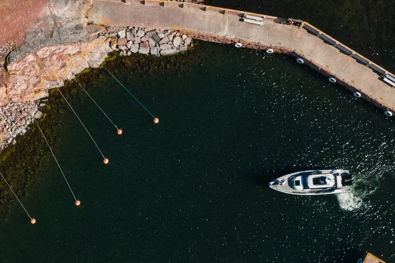 Slide: The Image of Aerial view of XO DFNDR 9 boat navigating near rocky shoreline, 2027 model. - 8