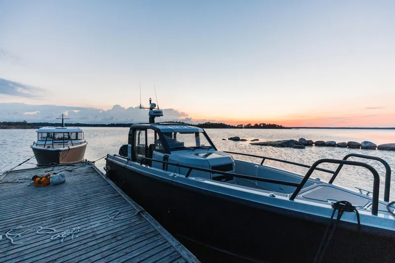 The Image of 2027 XO DFNDR 9 boat docked at sunset, serene waterfront view. - 9
