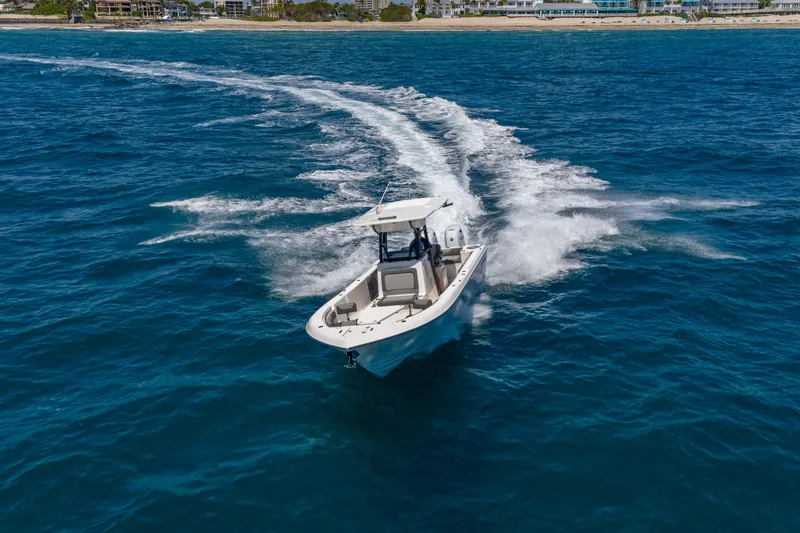 Slide: The Image of 2026 Sea Born LX27 Center Console boat cruising on open ocean near coastline. - 11