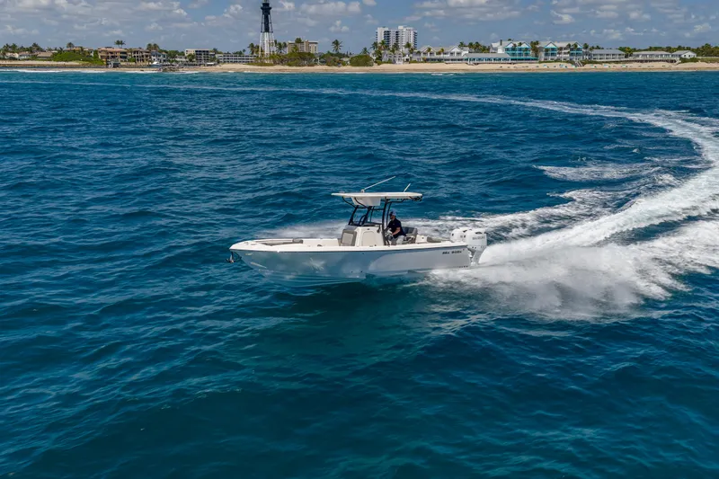 Slide: The Image of 2026 Sea Born LX27 Center Console boat cruising on ocean near coastline. - 12