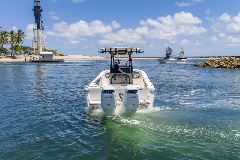 Slide: The Image of 2026 Sea Born LX27 Center Console boat cruising near a lighthouse on a sunny day. - 16