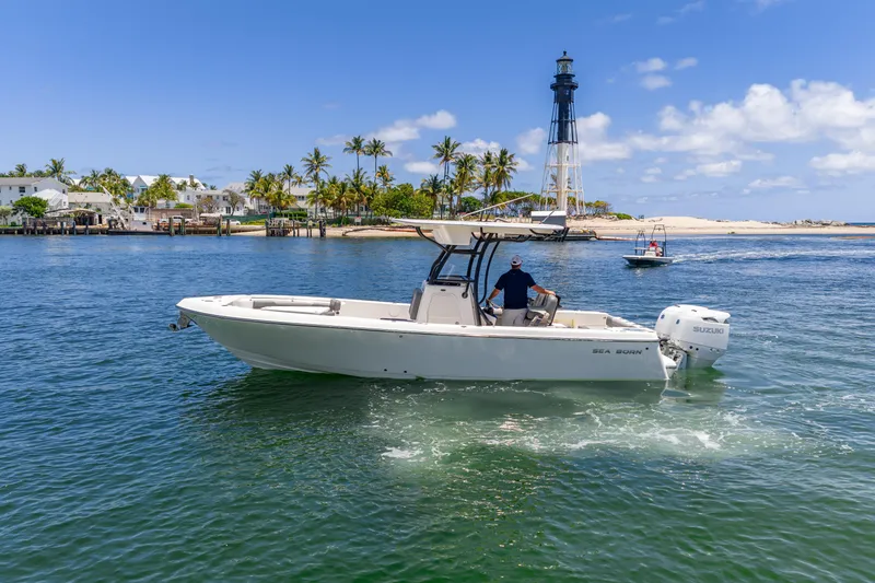 Slide: The Image of 2026 Sea Born LX27 Center Console boat cruising near a lighthouse on a sunny day. - 22