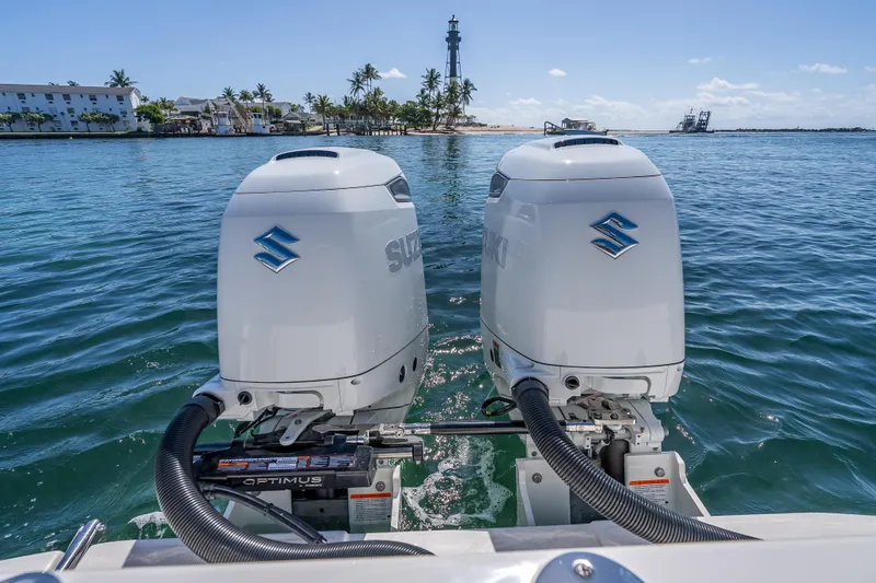 Slide: The Image of Twin Suzuki outboard engines on a 2026 Sea Born LX27 Center Console boat in clear waters. - 25