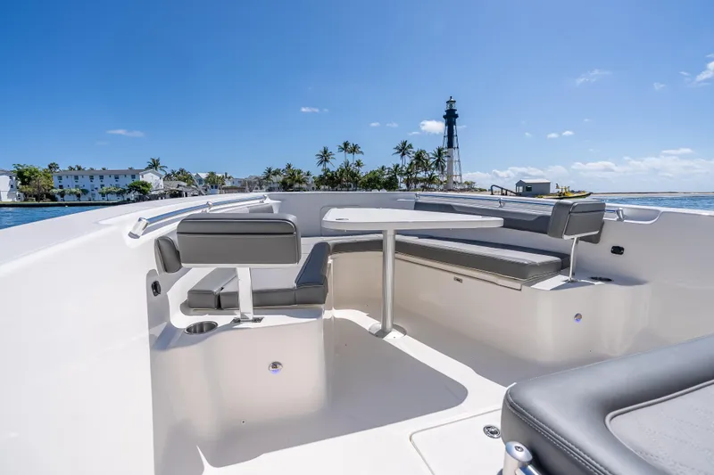 Slide: The Image of 2026 Sea Born LX27 Center Console boat interior with seating, table, and ocean view. - 49