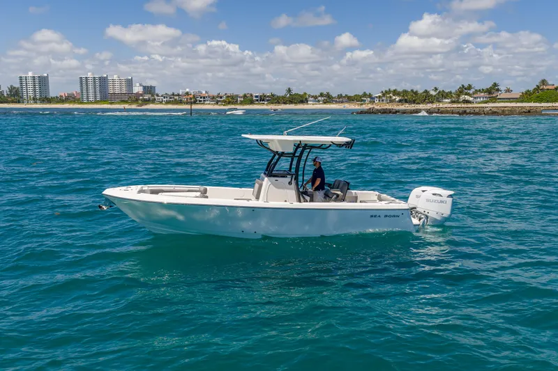 Slide: The Image of 2026 Sea Born LX27 Center Console boat cruising on blue ocean near coastline. - 5