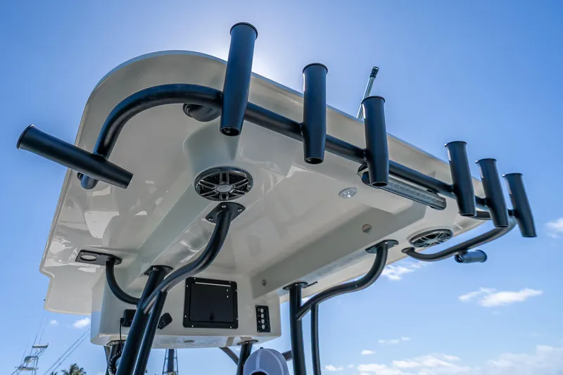 Slide: The Image of 2026 Sea Born LX27 Center Console boat with rod holders and speakers under blue sky. - 51